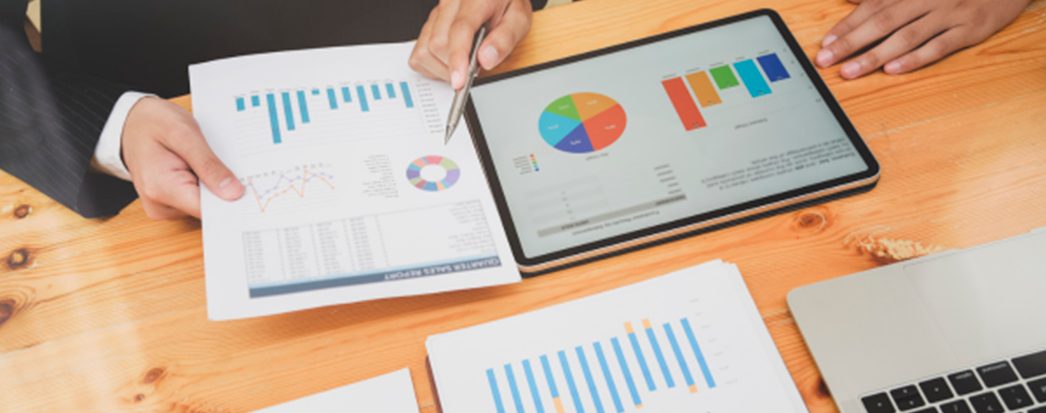 tablet, papeis a mesa com gráficos