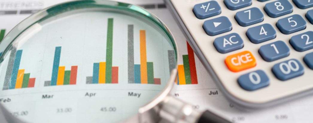 lupa, papeis com gráficos, calculadora a mesa