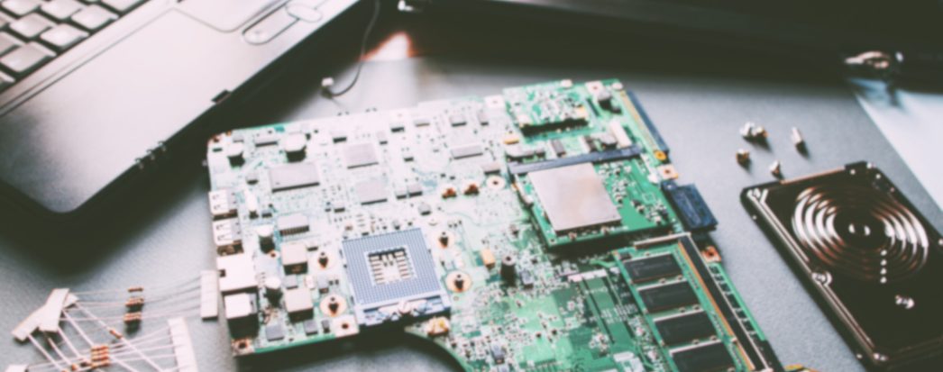 placa de computador e peças na mesa representando depreciação de informatica
