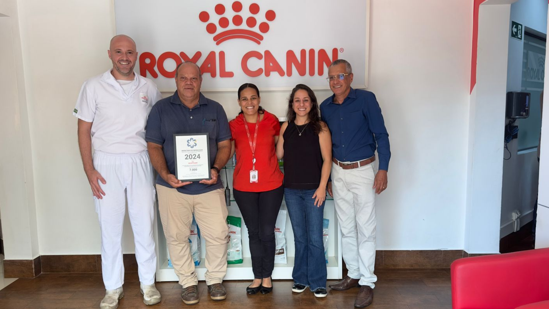 equipe responsável pelo contábil e inventário patrimonial da royal canin segurando placa de reconhecimento