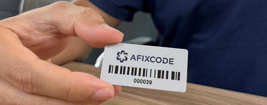 mãos masculina segurando uma tag de rfid com o logo da afixcode